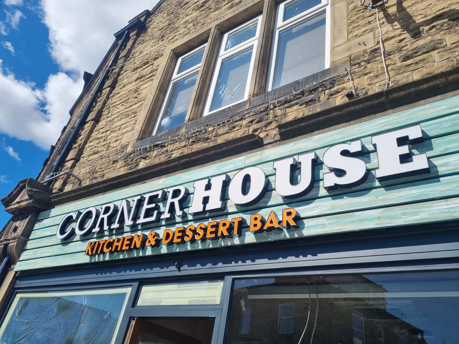 Corner House Cafe stone exterior with illuminated signage.